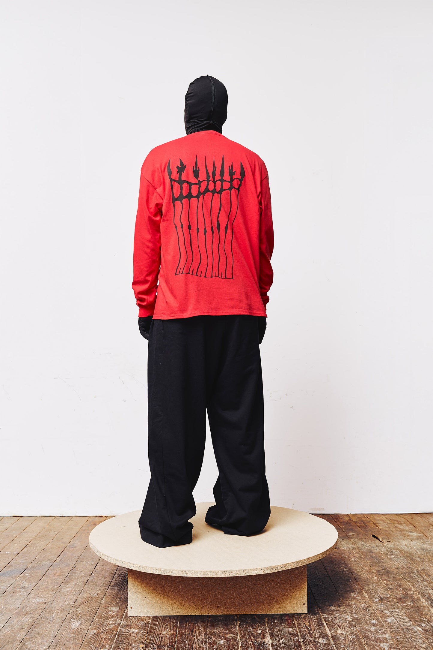 Man wearing red "Slayer" long sleeve by A BIT FRESH AIR, back view with screen print of a cemetery entrance.