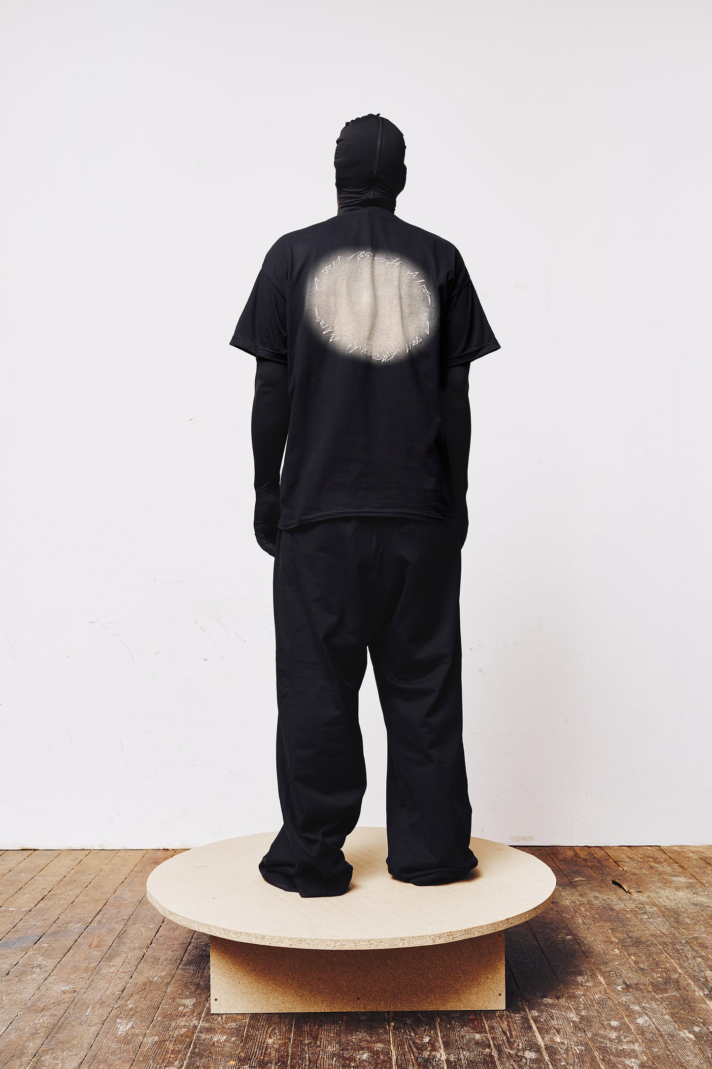 Back view of a man wearing a dark blue A BIT FRESH AIR T-shirt with a white faded circle and puff print logo.