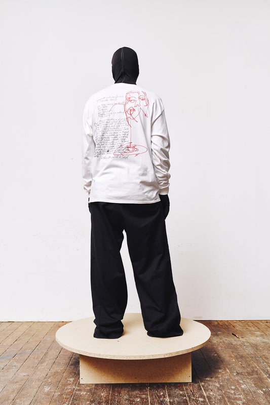 Man wearing a white A BIT FRESH AIR longsleeve featuring a spaghetti recipe on the back and a red face illustration by Dennis Loesch."