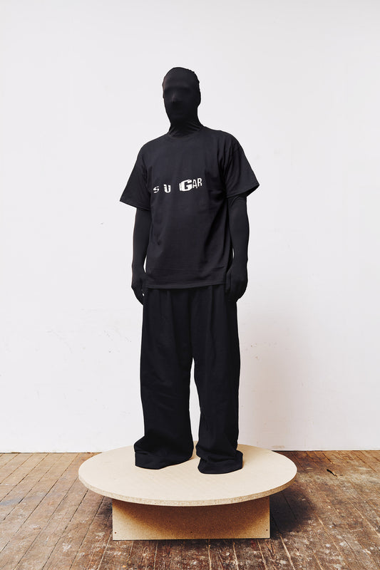 Man wearing a black A BIT FRESH AIR T-shirt with a white 'SUGAR' print on the chest.